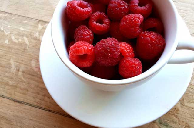 raspberries in a coffee cup